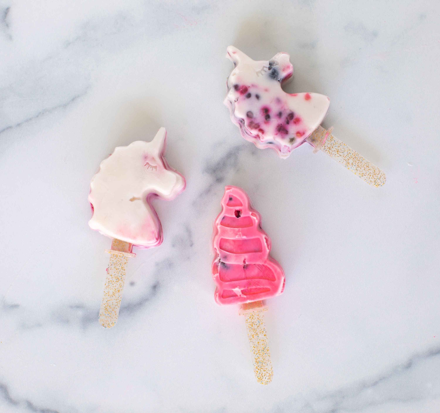 lifestyle image of unicorn and rainbow shaped ice pops