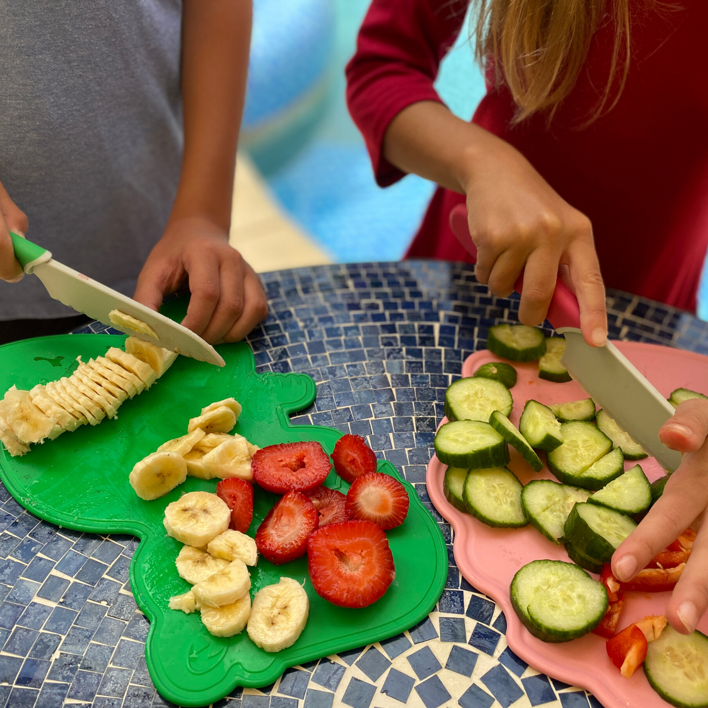 Dinosaur Shaped Kids Cutting Board and Safe Knife Set used to slice bananas, strawberries, and cucumbers.