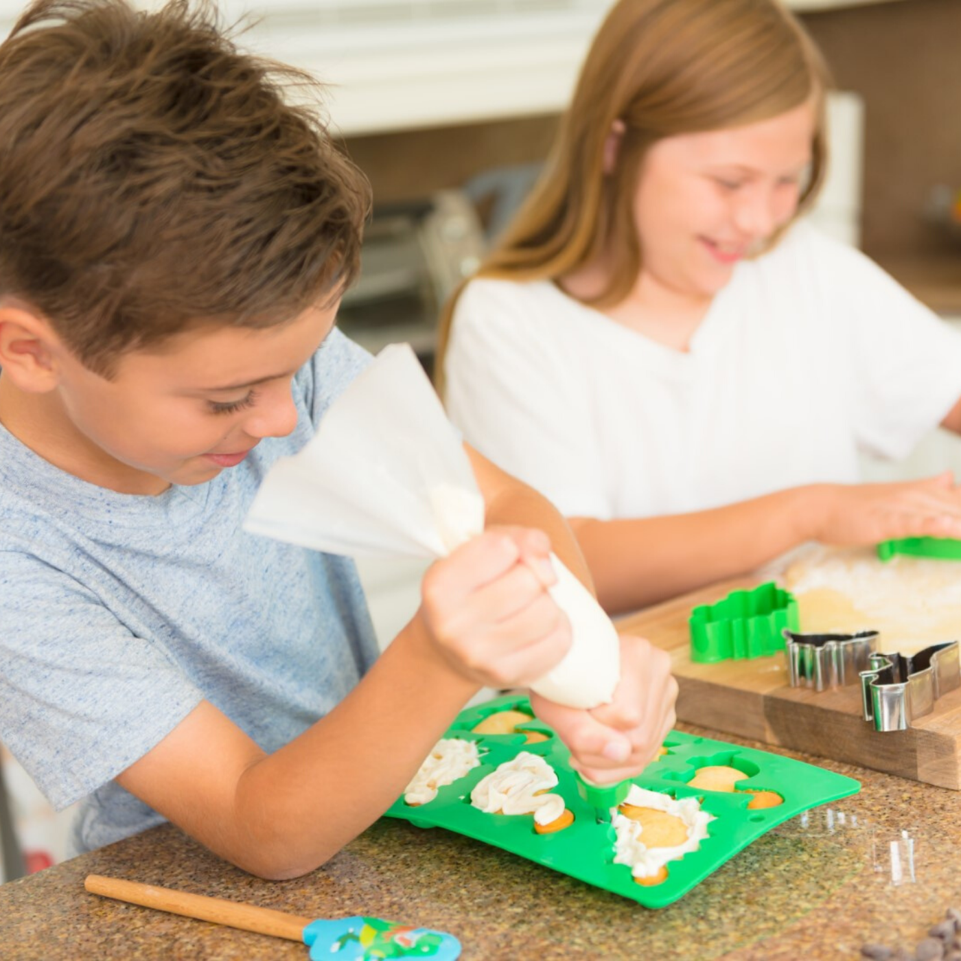 Children frosting cupcakes made using Dinosaur Ultimate Baking Party Set