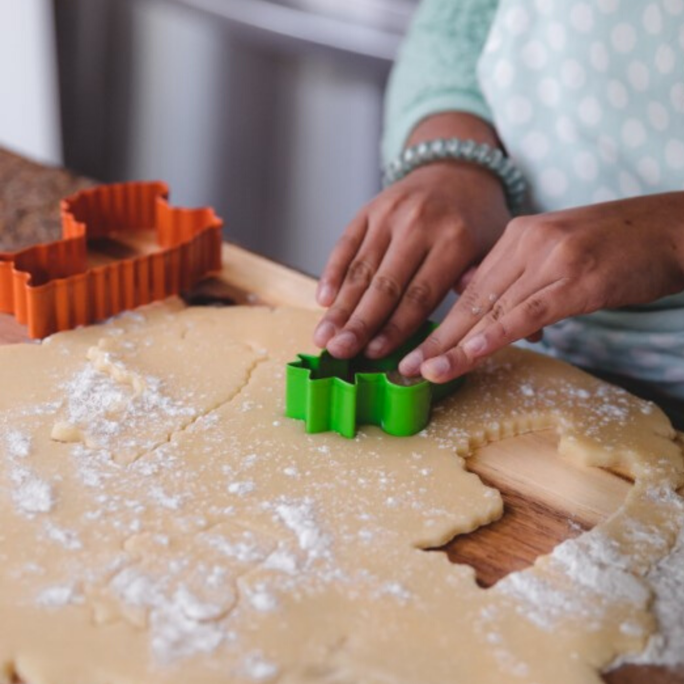 Lifestyle photo of child cutting cactus shaped cookie using Llama Love & Cactus Stainless Steel Cookie Cutters