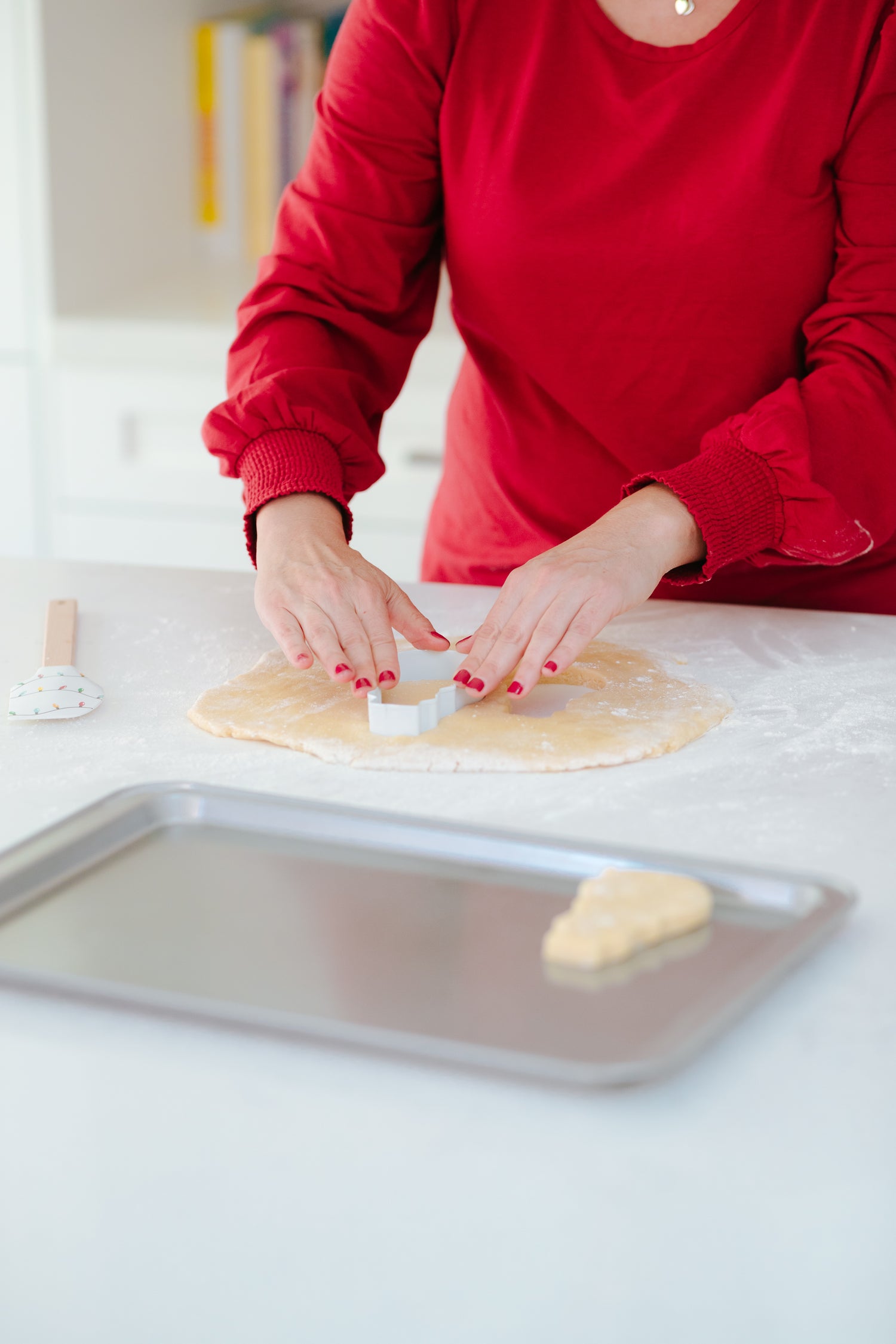 Lifestyle image of a person using the snowman cookie cutter to cut out cookies