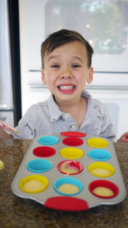 Lifestyle image of a happy child baking mini cupcakes 