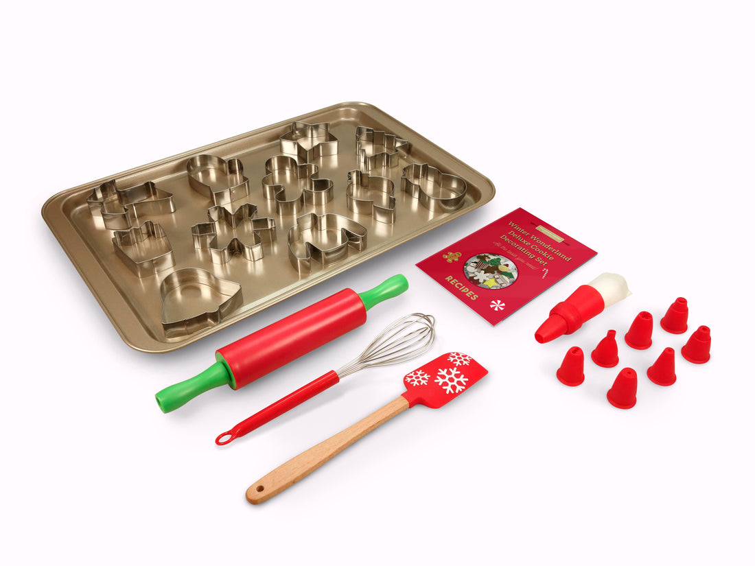 Out of box image of Winter Wonderland Deluxe Cookie Decorating Set. Includes: 1 large non-stick baking sheet, 12 stainless steel cookie cutters (sweater, reindeer, star, mitten, gingerbread man, gift, ornament, bell, stocking, snowman, snowflake, Christmas tree), 1 whisk, 1 spatula, 1 rolling pin, 5 frosting bags with coupler, ring and 8 tips and recipes.