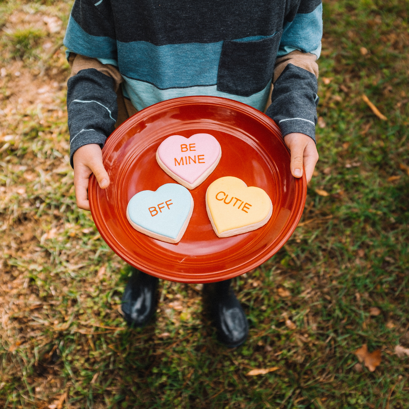 Lifestyle image of 3 heart shaped cookies that each say &quot;be mine&quot;, &quot;bff&quot;, and &quot;cutie&quot;