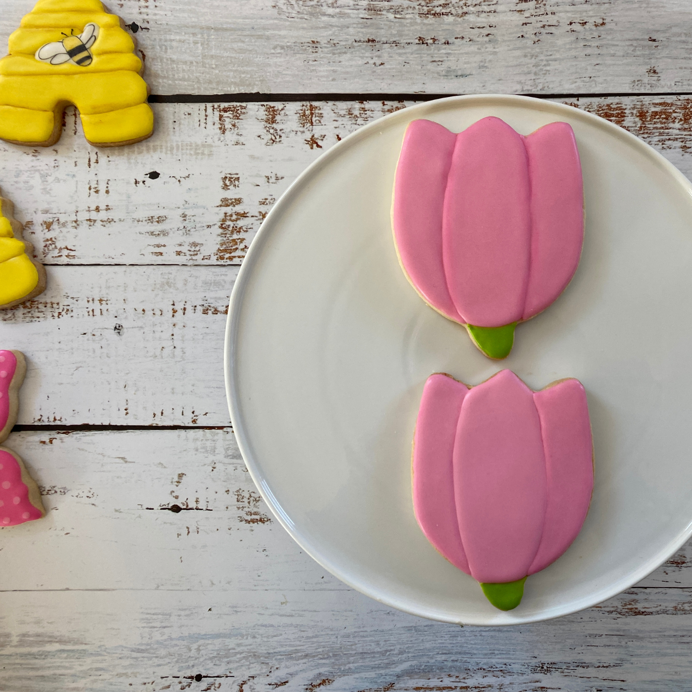 Lifestyle image of two decorated tulip cookies 