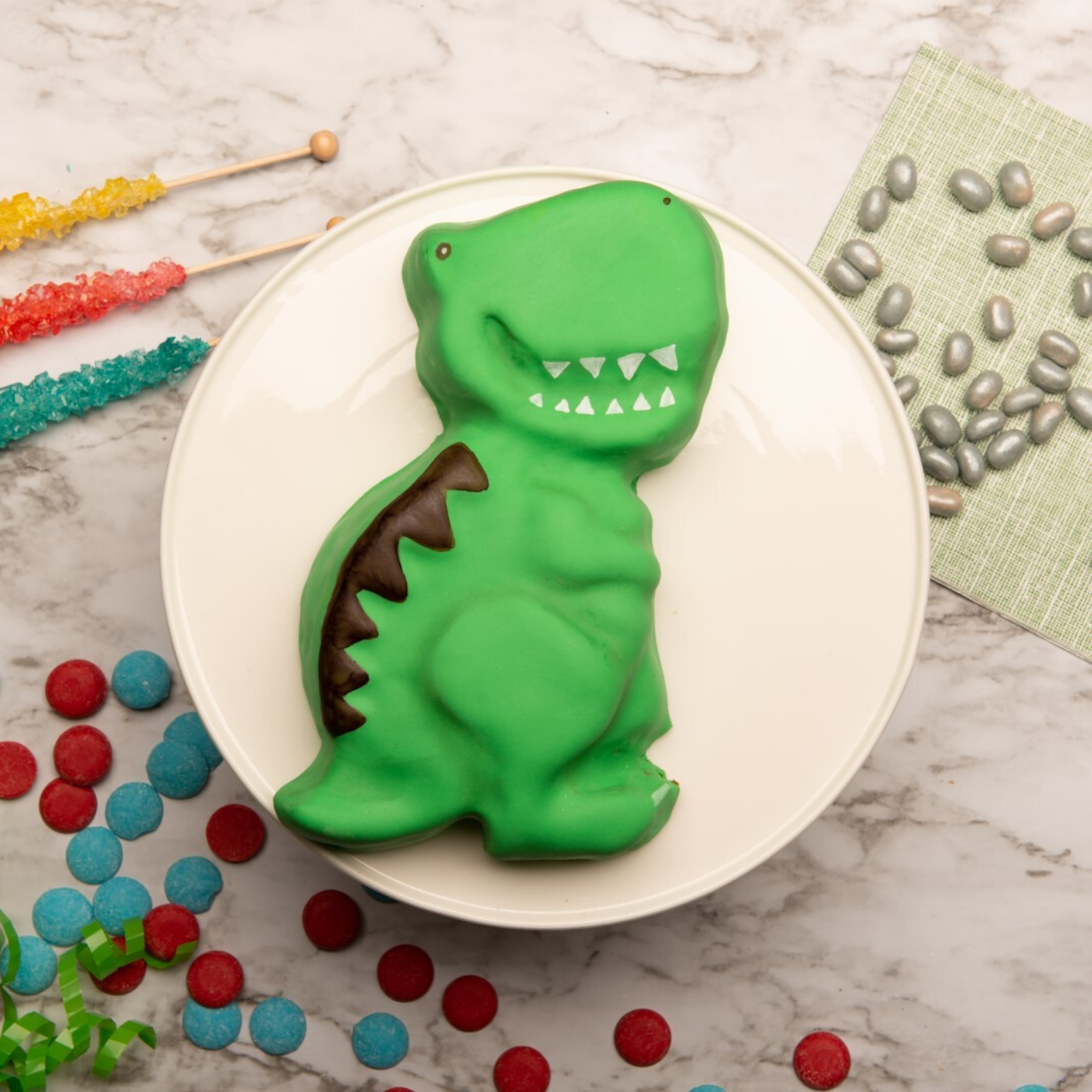 Decorated dinosaur shaped cake created using Dinosaur Large Cake Making Set