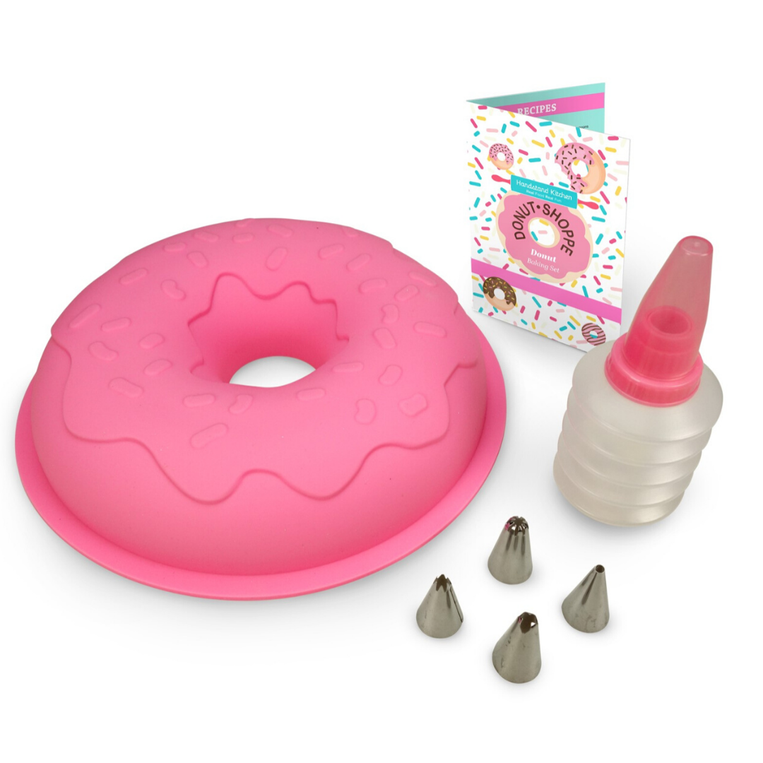 Out of box image of Donut Shoppe Large Cake Making Set including 1 large silicone donut cake mold, 1 frosting bottle with  cap, 1 frosting coupler with ring and 4 tips, and recipes