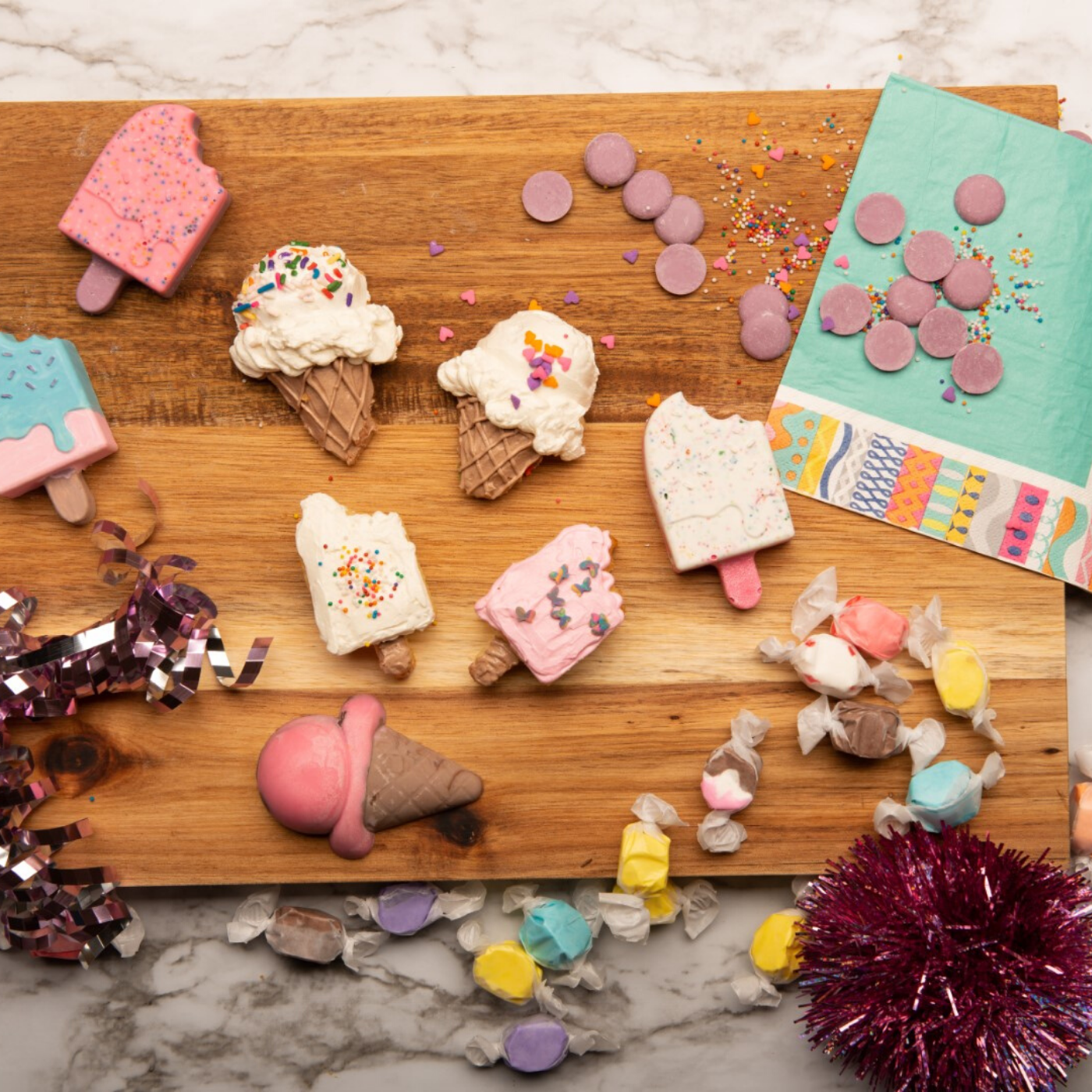 Lifestyle image of popsicle and ice cream cone shaped cupcakes decorated with icing created with Ice Cream Parlor Cupcake Mold