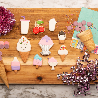 Lifestyle image of : 1 ice cream cone, 2 sundaes, 1 cherry, 1 milkshake, 1 drink cup, 2 popsicles and 2 ice cream cone decorated cookies made using the Ice Cream Parlor Cookie Cutter 10 Piece Boxed Set