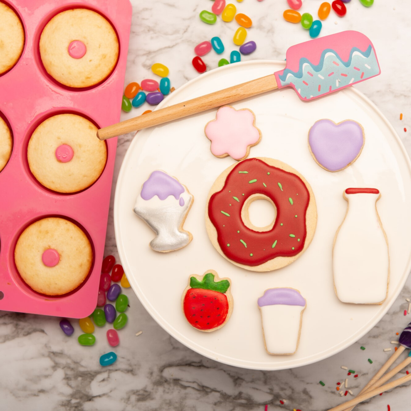 Lifestyle image of donut shaped cupcakes and cookies decorated with frosting