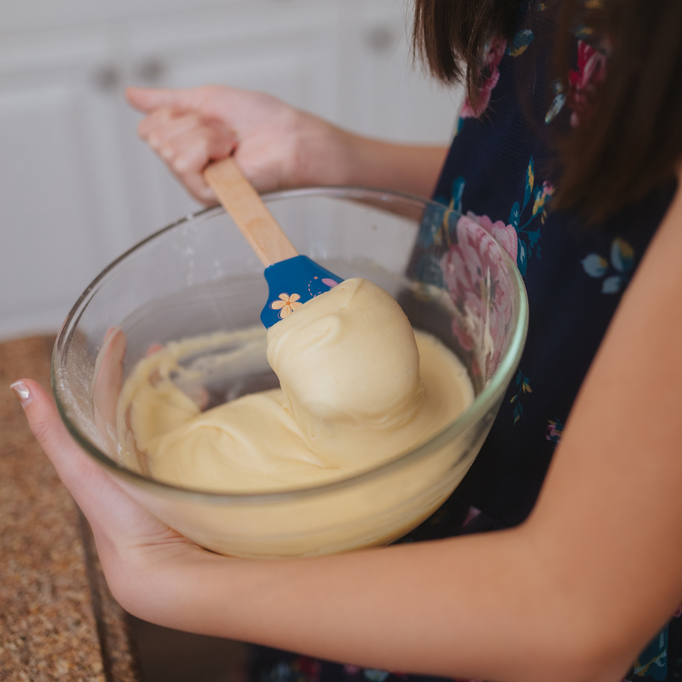 Lifestyle image of child using spring fling butterfly spatula to mix batter 