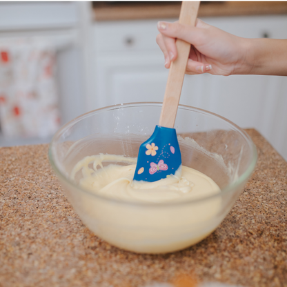 Lifestyle image of child using spring fling butterfly spatula to mix batter  Edit alt text