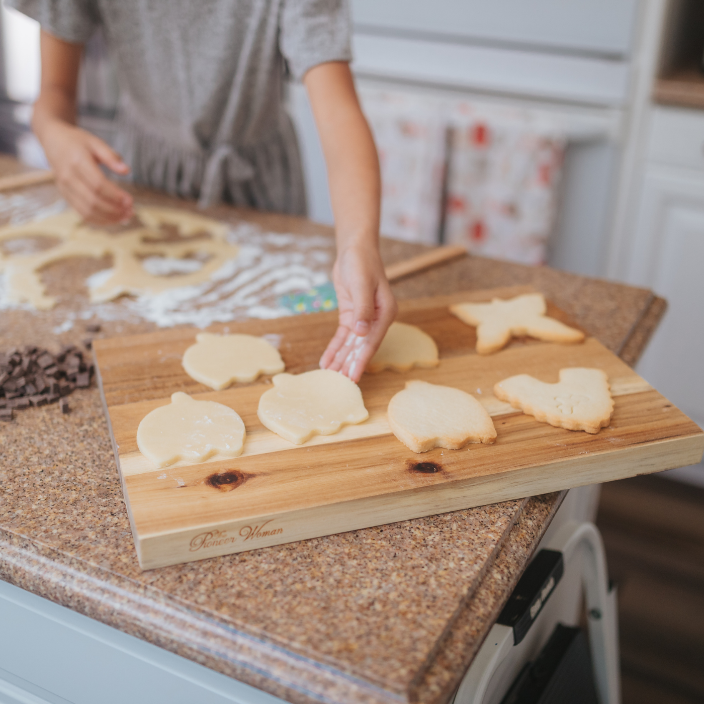 Lifestyle image of a person using the tulip cookie cutter to cut out cookies