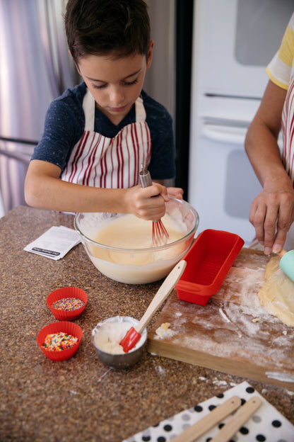 Young boy mixing cake batter and using Junior Baker Baking Set