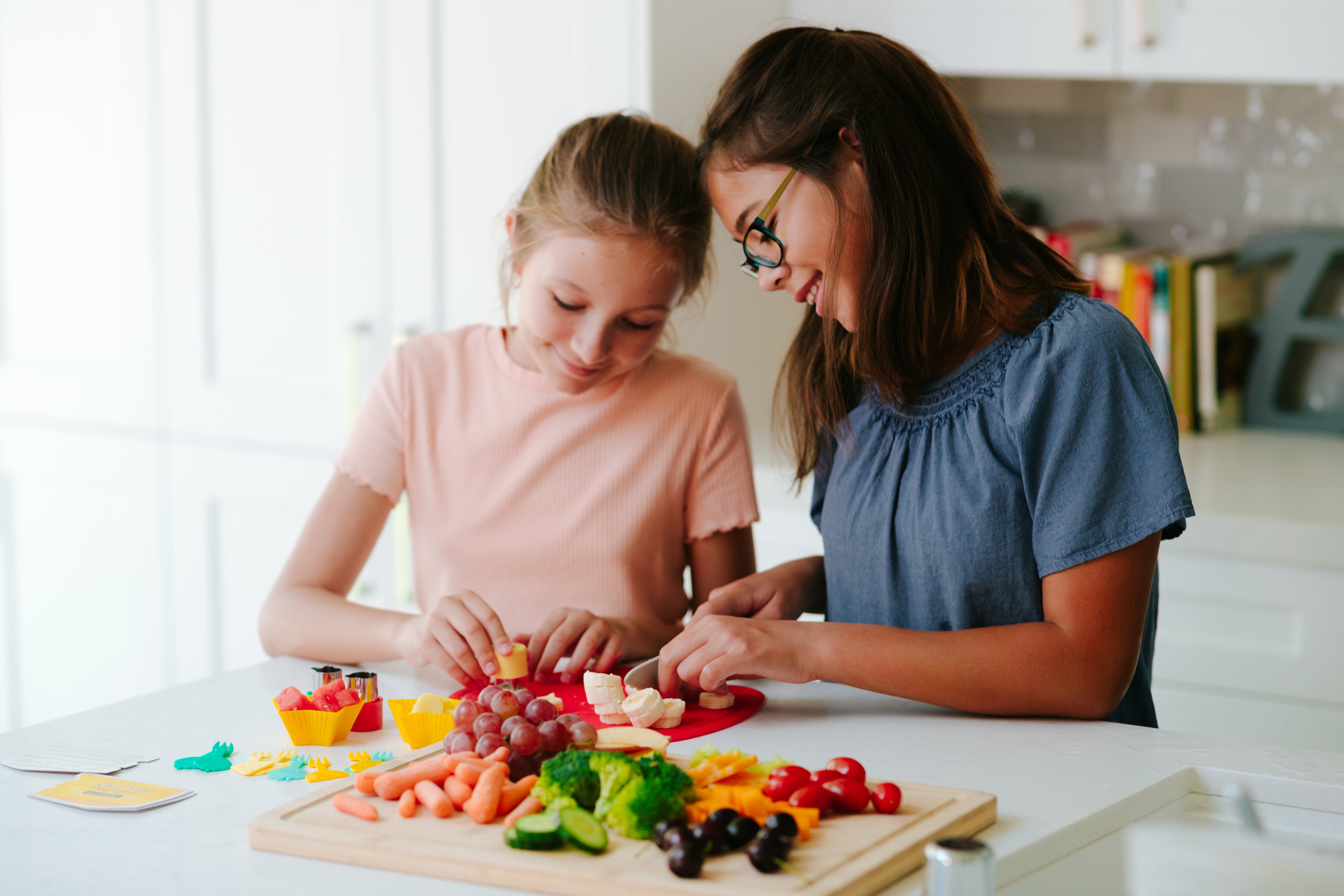 Lifestyle image of two children using Foodie Friends CHARcuteRIE Set to prepare fruits and vegetables