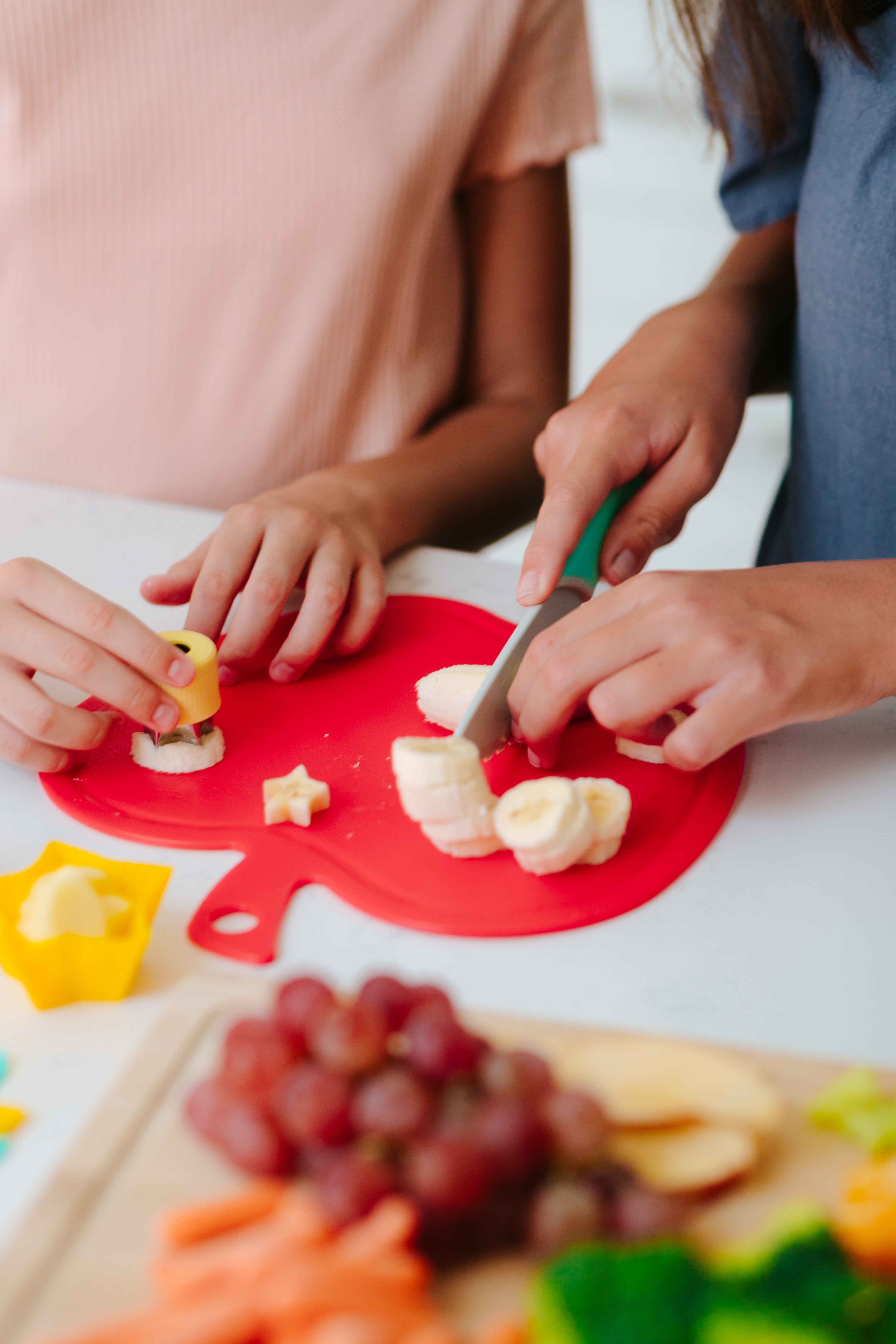 Lifestyle image of two children using Foodie Friends CHARcuteRIE Set to prepare bananas