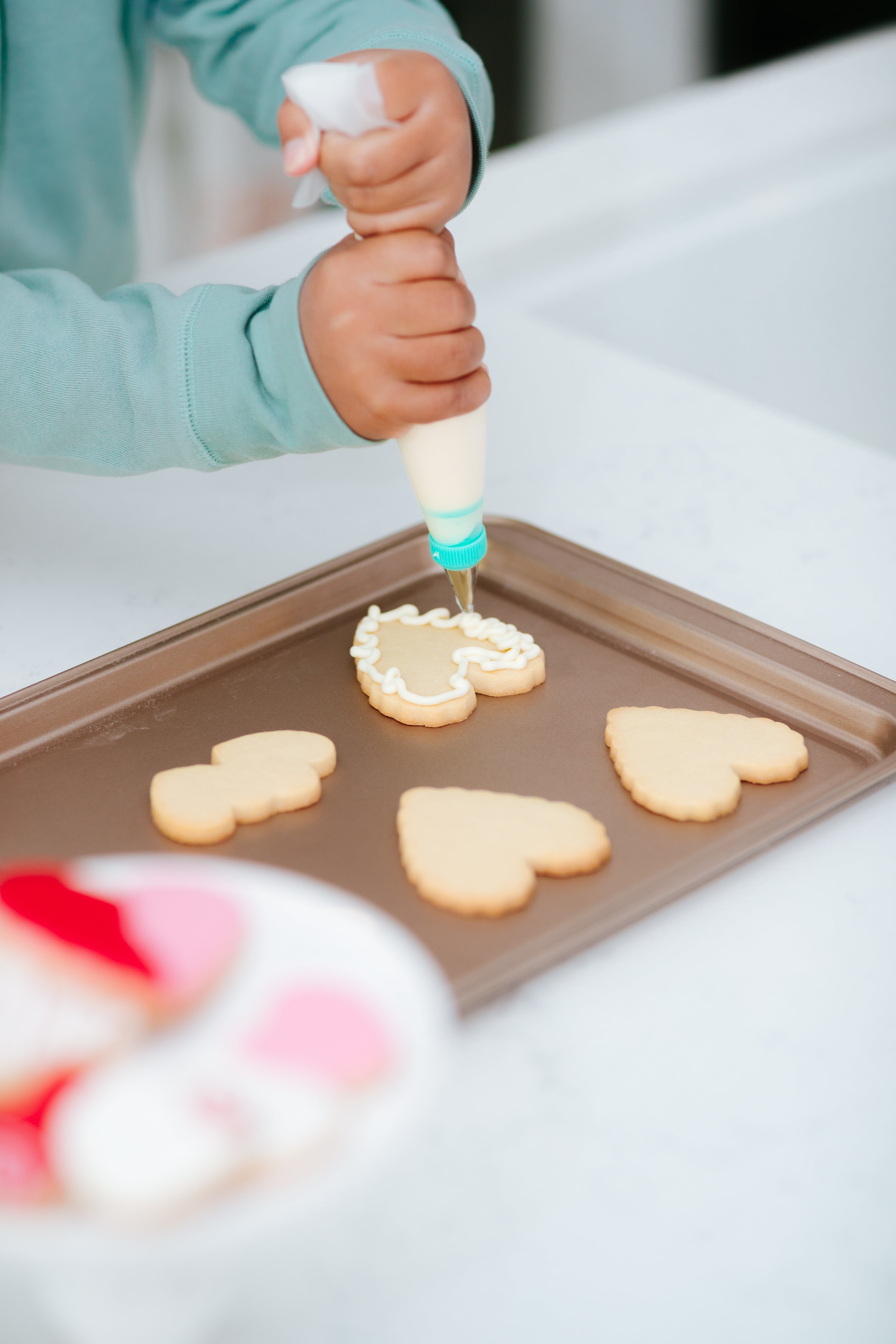 Lifestyle image of a person decorating the double heart cookies 