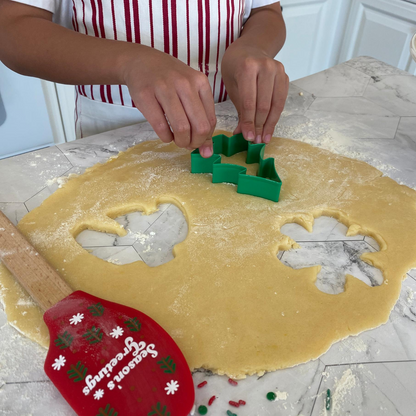 Lifestyle image of a person cutting out tree shaped cookies 